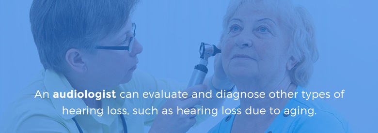 audiologist looking at patient's ears with otoscope